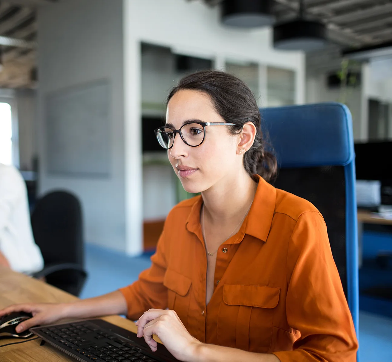 Beraterin mit Brille an einem modernen Arbeitsplatz